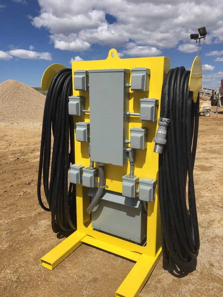 A yellow industrial machine with cables and components against a desert backdrop.