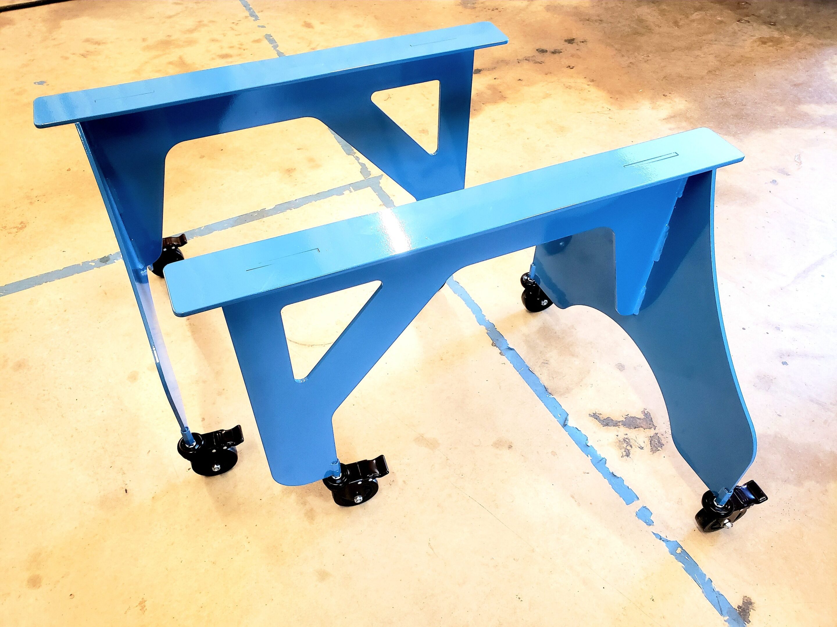 Blue metal frame with caster wheels on a concrete floor.