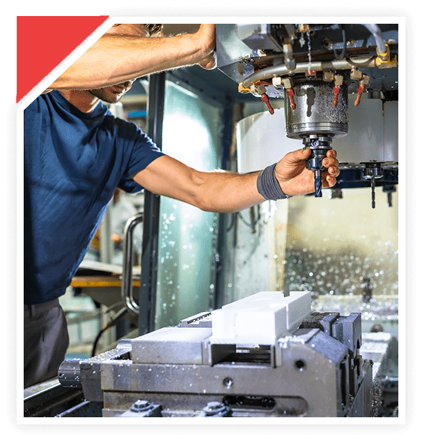 A man operating a milling machine in a workshop.