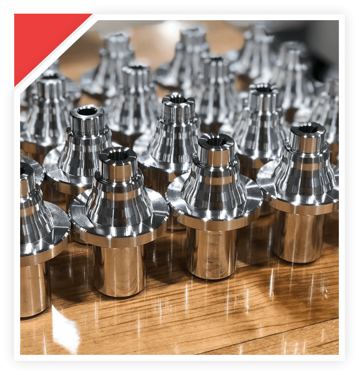 Close-up of shiny metal gears arranged on a wooden surface.